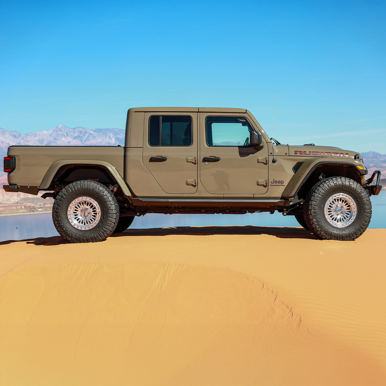 Jeep Gladiator JT equipped with Savvy Offroad LEGACY front bumper with hoop, BIG 10 rear bumper, and KRAWLER LITE bolt-on rock sliders on extreme off-road terrain