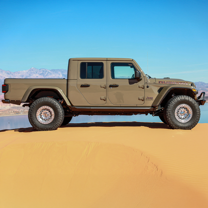 Jeep Gladiator JT equipped with Savvy Offroad LEGACY front bumper with hoop, BIG 10 rear bumper, and KRAWLER LITE bolt-on rock sliders on extreme off-road terrain